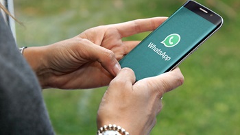 pessoa a segurar telemóvel com whatsapp
